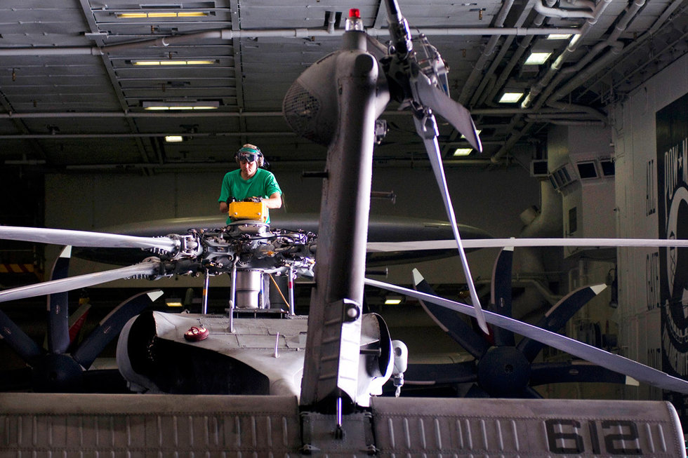 Những chiếc trực thăng của Hải quân Mỹ trong hầm tàu sân bay đang được sửa chữa để chuẩn bị làm nhiệm vụ