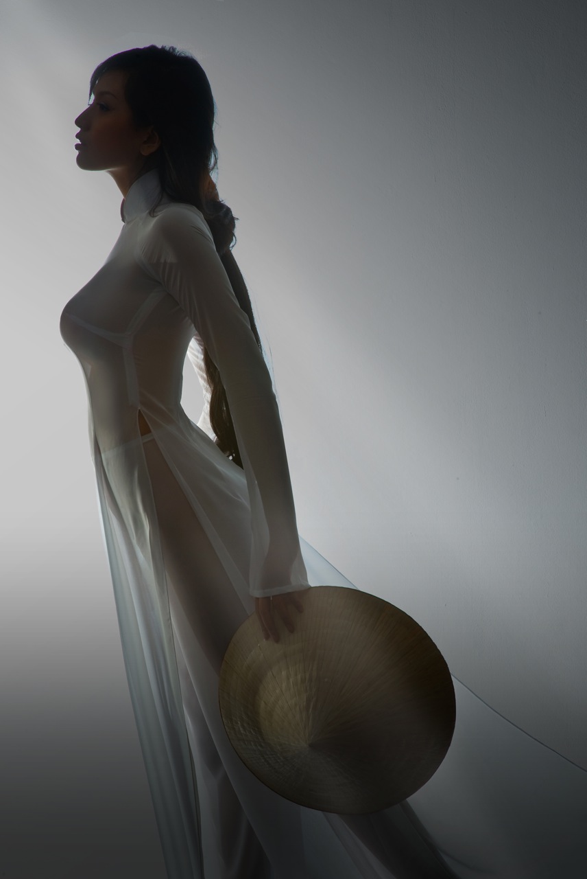 Trong vai trò mẫu ảnh Hoa hậu Việt Nam 2006 diện áo dài trắng, mỏng manh, chụp với phụ kiện nón lá và hoa sen.