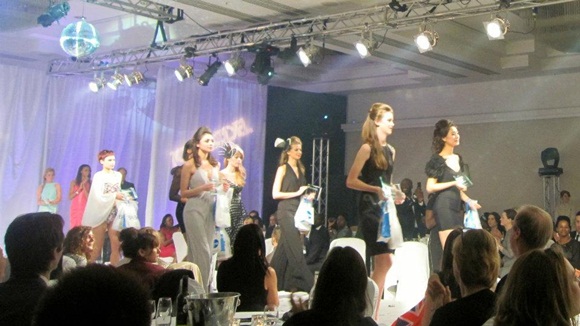 Các thí sinh cầm giải thưởng và cup chương trình tiếp tục trình diễn thời trang
