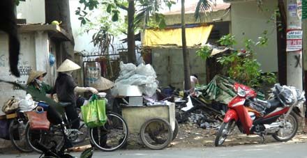 Những người mua bán ve chai chờ đợi, thu lượm đồ vật bị cháy do nhà bé gái vứt đổ tại bãi rác gần đó (Ảnh SGTT, VTC, TNO) 