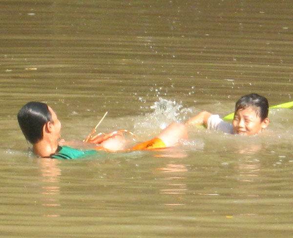 Hà Văn Luận (áo xanh) đang tắm sông