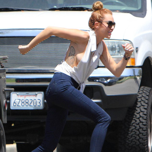 Miley đáng yêu vui đùa khắp khu nhà mà quên mất là cánh paparazzi đang giơ sẵn ống kính chỉ chờ áo cô bay lên.
