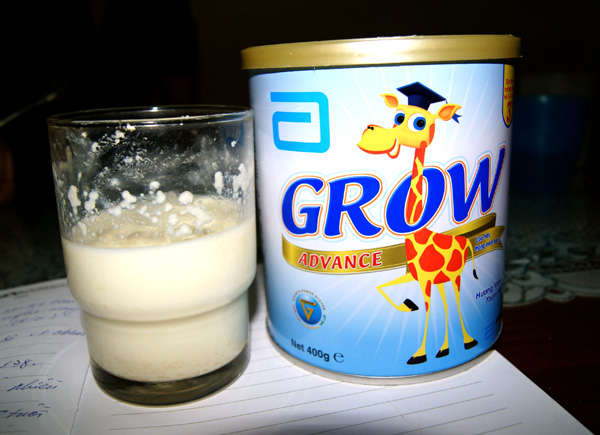 Trên thành cốc là những cục sữa vón lại và nổi lên trên mặt cộc sữa Grow Advance của Abbott.