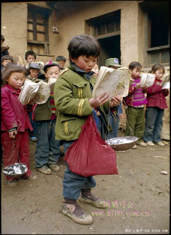 Những trẻ em nghèo tại 1 huyện miền núi của tỉnh Vân Nam đang học bài ngoài trời vì không có lớp học trong khi thời tiết ngoài trời chỉ khoảng 3-4 độ C. Mỗi 1 học sinh tay cầm sách và 1 khay đựng củi để sưởi ấm