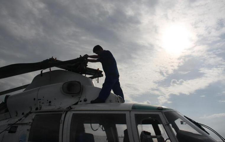 Binh lính trên tàu Hải giám Trung Quốc đang sửa chữa cánh của 1 chiếc trực thăng trên tàu Hải giám số 83