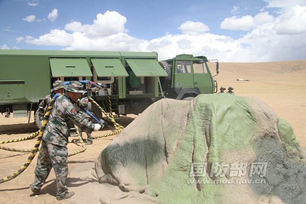 Lính Trung Quốc tiến hành ngụy trang che giấu thiết bị giả làm những tảng đá