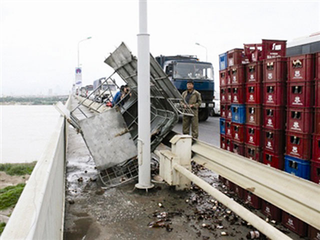 Hiện trường chiếc xe tải chở bia xấu số gặp nạn trên cầu Thăng Long khi xe lao vào ổ gà làm tài xế mất lái. Những trường hợp như thế này không phải hiếm gặp trên cầu Thăng Long từ sau ngày đại tu cầu cuối năm 2009.
