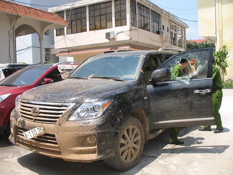 Chiếc xe sang vẫn còn bám nguyên bùn đất, để mở được cửa xe, lực lượng công an đã phải dùng búa đập vỡ kính xe.