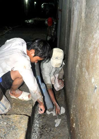 Công nhân trát xi măng chống thấm dưới hành lang thu gom nước trong hầm. Hầu hết công nhân này là lao động phổ thông, thanh niên đồng bào thiểu số ở huyện Bắc Trà My và các địa phương lân cận. 