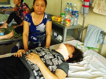 Bà Lê Thị Liên đang nằm điều trị tại bệnh viện vì bị chồng và con đánh chấn thương đốt sống cổ