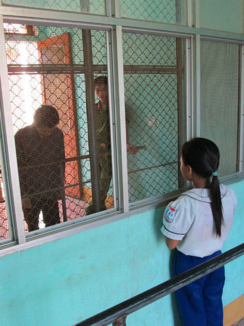 Giây phút trùng phùng qua song sắt trại giam.