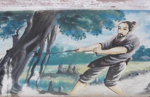 Phật Thầy Tây An Đoàn Minh Huyên kéo cây đa già ở Tòng Sơn để dẹp đường cho dân đi.
