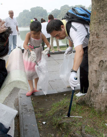 Ông Ninomiya, một doanh nhân người Nhật Bản cùng nhiều đồng nghiệp và em nhỏ cặm cụi nhặt rác quanh bờ hồ Gươm