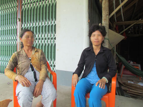 Bà L ngồi bên phải trước căn nhà mình