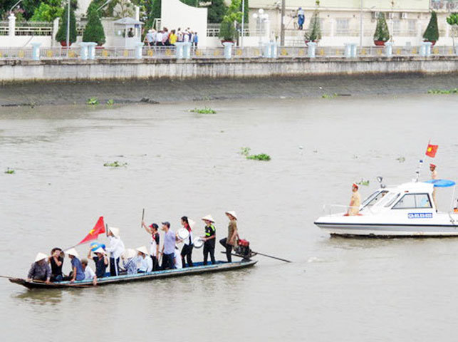  Dưới sông Masprero cũng có nhiều người căng cờ, băng rôn la hét.