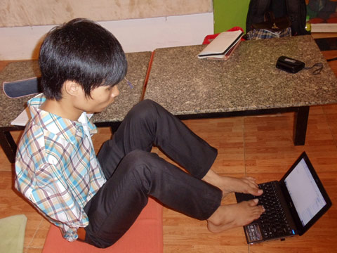 Dù không có đôi tay nhưng Nguyễn Minh Phú sử dụng thành thạo máy tình và hiện là sinh viên năm thứ 2