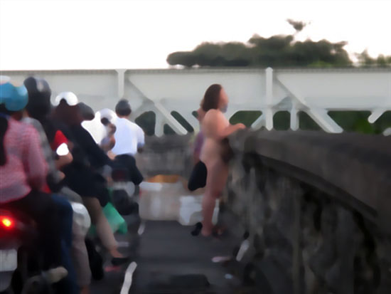  Sau khi mặc váy vào được khoảng 20 phút, người phụ nữ lại cởi ra và cứ thế đứng khỏa thân trên cầu hàng tiếng đồng hồ.