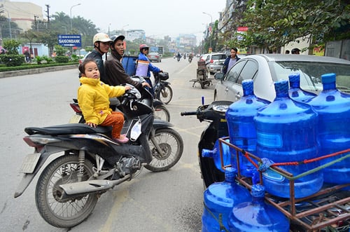 Bé gái này cũng rất muốn được vào gần xem cho rõ nhưng mẹ bé đã dặn con: “Ngồi yên đây trông xe”. Còn bà mẹ đã hòa vào đám đông hiếu kỳ.