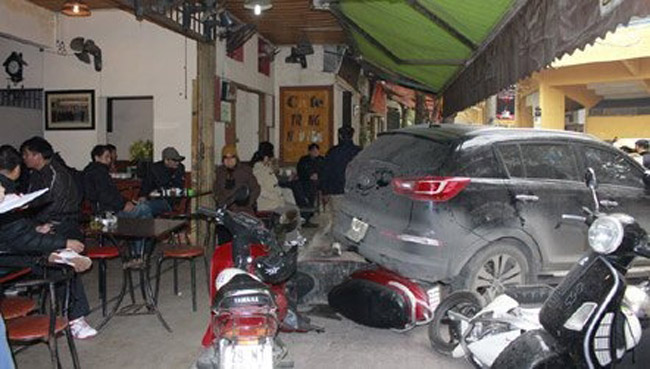 Một xe ô tô Kia Sportage cài số lùi bất ngờ lao vào quán cafe đâm hư hỏng 5 xe máy và làm một khách bị thương nhập viện.