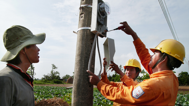 Công nhân ngành điện lắp đặt điện kế cho một hộ nông dân ở ấp Giồng Giữa, thị trấn Lịch Hội Thượng, huyện Trần Đề, tỉnh Sóc Trăng - Ảnh: Nguyễn Công Thành