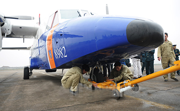 Lực lượng kỹ thuật lắp thiết bị để lai dắt máy bay.