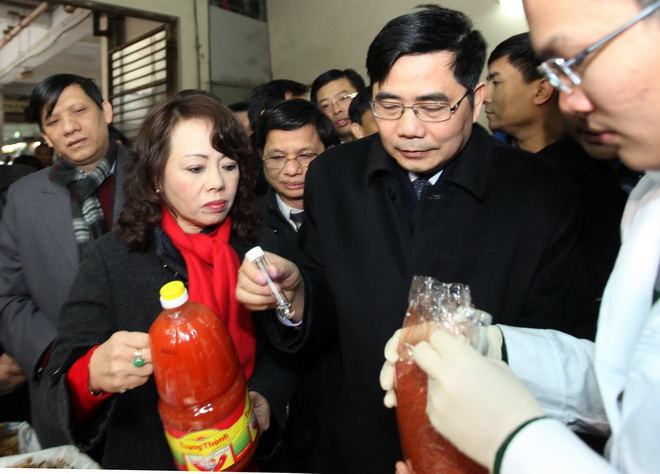 Bộ trưởng Nguyễn Thị Kim Tiến và Bộ trưởng Cao Đức Phát (thứ 2 và 3 từ trái sang) kiểm tra tương ớt và màu điều tại chợ Đồng Xuân - Ảnh: Việt Dũng