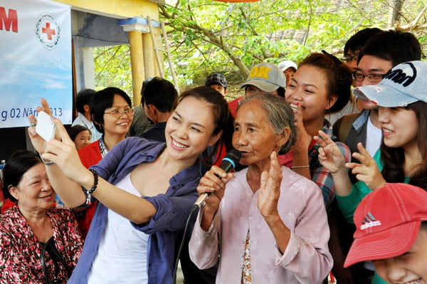  Họa mi tóc nâu vui vẻ tự chụp ảnh lưu niệm bằng điện thoại cùng cụ bà và các fan.