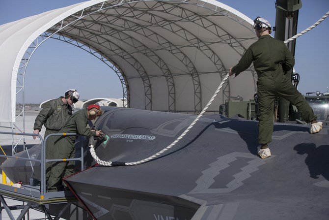 Các nhân viên đang cắm chốt lên thân của một chiếc F-35B - biến thể cất cánh đường băng ngắn và hạ cánh thẳng đứng.