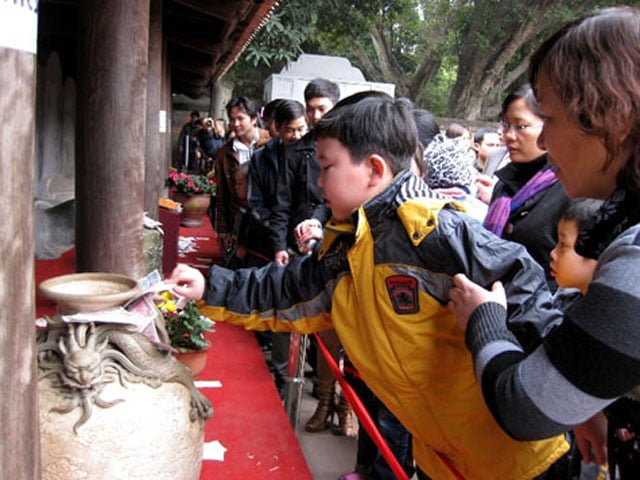 Người phụ nữ này còn cho cả con nhỏ cố nhét tiền lẻ vào hiện vật trong Văn miếu Quốc tử giám.