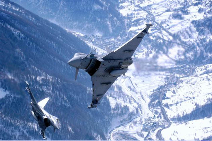 Hai máy bay phản lực Eurofighter Typhoon cơ động giữa các đỉnh núi tuyết của dãy núi Alps.