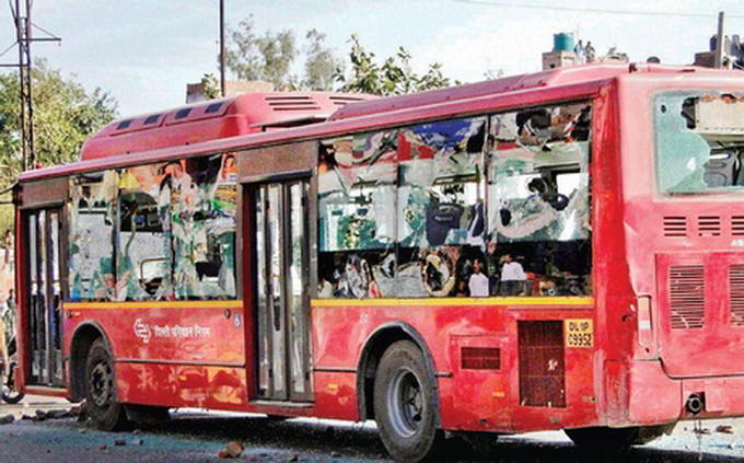 Một xe buýt bị hư hại do người biểu tình đập phá - Ảnh: PTI