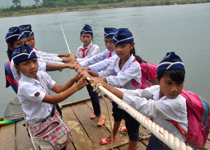 Hàng trăm học sinh ở xã Sơn Ba, huyện Sơn Hà đu dây thừng kéo bè qua sông mỗi ngày. Mỗi tháng, gia đình một học sinh nộp hai ang lúa (tương đương 60.000 đồng) để trả tiền bè đến trường.