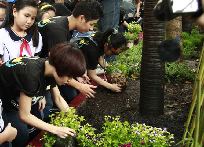   Quán quân Idol 2010 Uyên Linh và MC Nguyên Khang trồng cây xanh cùng học sinh TP HCM để ủng hộ chương trình Giờ Trái Đất.