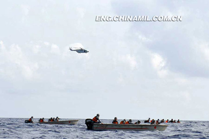 Binh sĩ trên các tàu đổ bộ chuẩn bị tiếp cận đảo dưới sự yểm trợ của trực thăng chiến đấu. Ảnh: Chinamil
