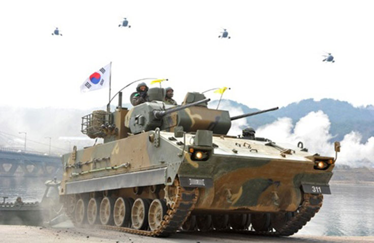 Cuộc tập trận xe tăng diễn ra hôm qua tại huyện Hwacheon, gần biên giới với Triều Tiên, với sự tham gia của các xe bọc thép, xe tăng, trực thăng. Trong ảnh, một chiếc xe bọc thép phòng không đi qua cầu, với sự hộ tống của các trực thăng chống tăng phía trên. Ảnh: AFP