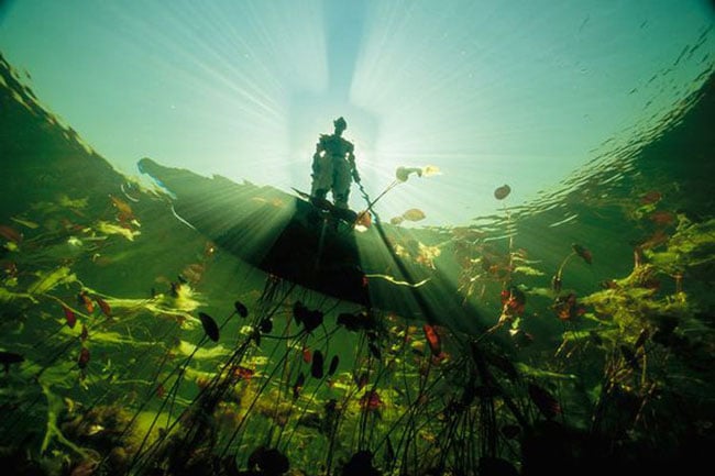 Trong hình là một người dân nơi đây đang chèo xuồng dọc theo dòng sông Okavango, con sông dài thứ 4 ở phía nam của châu Phi. Con sông này bắt nguồn từ Angola và dài khoảng 1.600km sau đó đổ vào Botswana, nơi nó tạo nên một vùng đồng bằng giống như một ốc đảo nằm giữa sa mạc Kalahari. Ốc đảo này là một khu bảo tồn và giống như một mê cung còn hoang sơ, nơi phục vụ nguồn nước cho các loài thực và động vật nơi đây. Vào mùa lũ, đầm lầy Okavango Delta có thể mở rộng diện tích lên tới 16.800 km2. Nhánh sông chính chảy qua rừng rậm, xavan khô, cồn và chảy về phía nam. Nhiều người cho rằng dòng sông có thể cung cấp nước cho các hoạt động nông nghiệp hay công nghiệp sẽ tốt hơn.