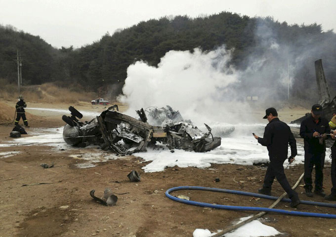 Lính cứu hỏa cố gắng dập tắt đám cháy trên xác chiếc trực thăng quân sự CH-53E Super Stallion sau khi gặp nạn trong quá trình hạ cánh. Chiếc trực thăng bốc cháy và rơi xuống trong khu vực trường bắn ở huyện Cheolwon, giáp giới Triều Tiên và cách Seoul 88 km về phía Bắc.