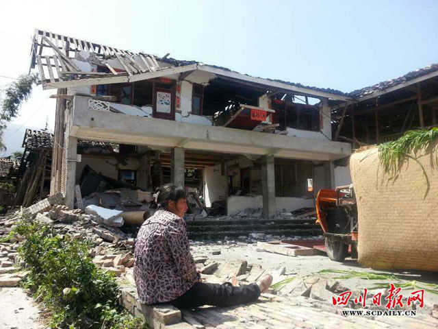 Một người dân Tứ Xuyên ngồi thẫn thờ trước ngôi nhà tan hoang sau trận động đất sáng nay.