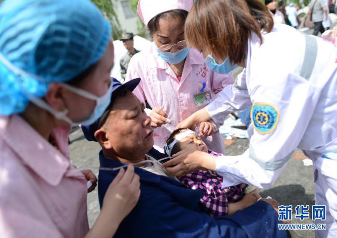 Một bé trai đang được cấp cứu. Các đội cứu thương nhanh chóng được thành lập để đến khu vực bị động đất. Chính quyền tỉnh Tứ Xuyên đã ban bố tình trạng khẩn cấp cấp I.