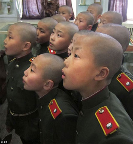 Các tân binh “nhí” này mới chỉ 11 tuổi. Các học viên mặc đồng phục quân đội và được dạy diễu hành một cách bài bản, thậm chí còn mang theo cả súng trên vai. Trường học này do nhà nước điều hành và cũng là nơi cố chủ tịch Kim Jong-il từng học trong chiến tranh Triều Tiên. 