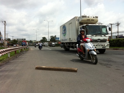 Một khúc gỗ do xe tải làm rơi trên QL1A (đoạn qua phường Linh Trung, Thủ Đức) gây nguy hiểm cho người tham gia giao thông.