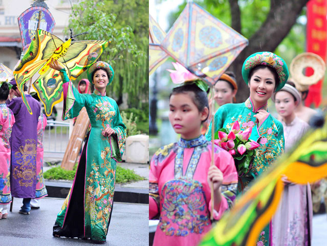    Hoa hậu diện áo dài hoàng hậu với những họa tiết được thêu tay tỉ mỉ. Cô đi bộ cùng đoàn rước từ công viên Tứ Tượng đến sân khấu Bia Quốc Học. Mặc dù đường phố ướt vì mưa nhưng người đẹp vẫn giữ nụ cười tươi tắn trong suốt hành trình. 