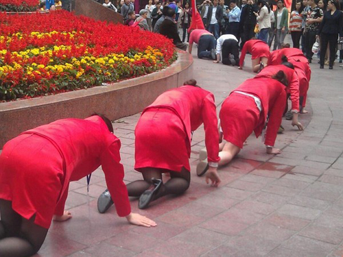 Các nữ nhân viên bị bắt bò giữa phố trước sự chứng kiến của  người đi đường - Ảnh: chụp từ blog của cư dân mạng Trung Quốc