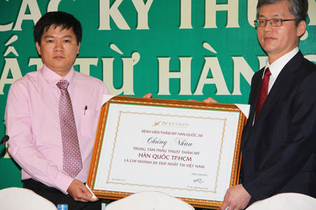 Viện trưởng Bệnh viện JW Hàn Quốc  Ts.Bs.Man Koon Suh trao bằng chứng nhận trao chứng nhận thương hiệu Thẩm mỹ Hàn Quốc JW duy nhất tại Việt Nam cho NCS.BS.Nguyễn Phan Tú Dung