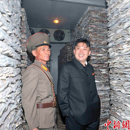 Ông Kim Jong-un vào kho của nhà máy, nơi có nhiều chồng cá đông lạnh dự trữ và nở nụ cười hài lòng.
