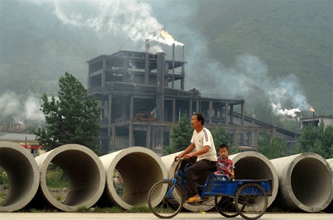 Người dân sinh sống giữa khói thải của một nhà máy xi-măng ở Baokang. (Ảnh: Reuters)