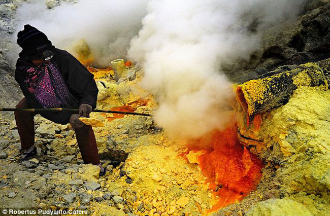 Một người thợ mỏ đang đạp vỡ khối lưu huỳnh ở bên ngọn núi lửa ở Indonesia.