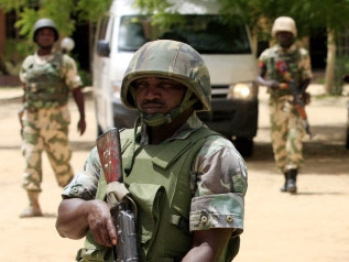 Quân đội canh gác trước trụ sở đài truyền hình nhà nước Nigeria ở Maiduguri, Nigeria. Nhóm khủng bố Boko Haram thường nhằm vào các cơ quan chính phủ nhưng gần đây lại nhắm đến thường dân.