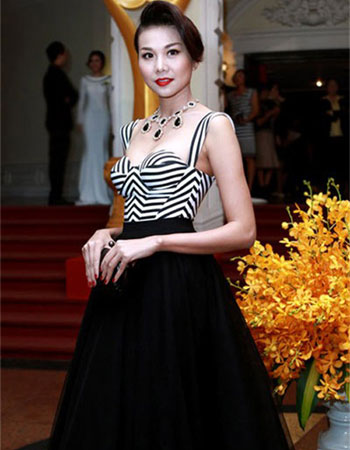 Áo bó sát đi kèm váy xòe cạp cao giúp kéo dài đôi chân của siêu mẫu Thanh Hằng.
