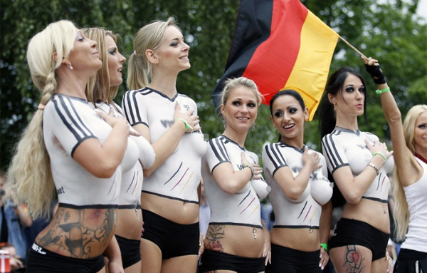 Trong khi người hâm mộ bóng đá thế giới đang hướng về Brazil nơi diễn ra các trận cầu sôi động ở World Cup 2014, tại Berlin, Đức một trận đấu hấp dẫn dành cho các nữ diễn viên phim khiêu dâm vừa được tổ chức để hâm nóng bầu không khí của ngày hội bóng đá lớn nhất hành tinh. Điều đặc biệt trận đấu này là các cô gái không mặc áo mà che cơ thể bằng màu sơn mẫu áo của đội mình. Trong ảnh là các cô gái của tuyển Đức đang làm lễ chào cờ trước trận đấu.
